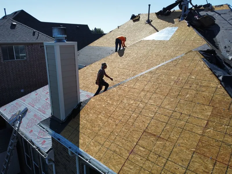 Viva Roofing crew working on new roof decking during a tear-off