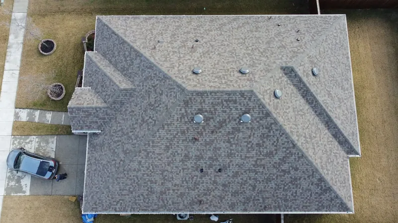 Drone view of a finished gray architectural shingle roof on a single-story home